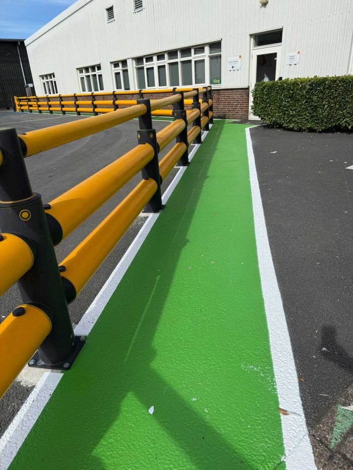 Duidelijk afgebakend looppad in groen bij ingang van bedrijfsgebouw